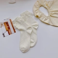 Détail de chaussettes blanc crème avec bordure en dentelle et motif jacquard ajouré - Taille unique / Beige