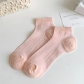 Pale pink crew socks with ribbed texture and reinforced heel in a lifestyle setting - One Size / Pink
