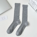 Vertical ribbed grey mid-calf socks displayed with modern minimalist home decor items - Grey Thin Ribbed Long