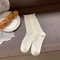 White crew socks with grey heart patterns and elegant ruffle edges on wooden desk - One Size / Heart