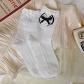 Chaussettes blanches en maille torsadée avec nœuds en satin noir et bords ondulés - Taille unique / Blanc