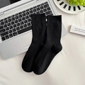 Klassische schwarze Socken mit vertikalem Rippenmuster auf einem silbernen Laptop - Mittleres Rippenmuster Schwarz