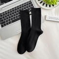 Klassische schwarze halbhohe Rippsocken aus Baumwollmischung, flach auf dem Laptop drapiert - Dünner Schwarzer Streifen