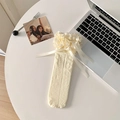 Cremeweiße Lolita-Wadenstrümpfe mit Spitzenrüschen und Satinschleifen auf weißem Schreibtisch - Einheitsgröße / Beige