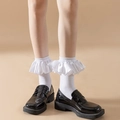 White crew socks with satin ruffle lace trim paired with black Mary Jane loafers - One Size / White