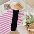 Calze nere con bordo a volant rosso e motivo a rete floreale su uno sfondo decorativo - Nero con bordo rosso