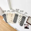 Flat lay of Japanese style mid-calf socks with lace bows and heart hollow patterns - Cream Lace Bowknot