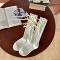 Calze alte color crema con fiocchi laterali su una scrivania in legno vintage - Taglia unica / Beige