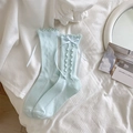 Light blue mid-calf socks with lace trim and bow detail on white fabric background - Blue / One Size