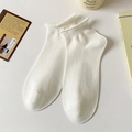 White minimalist cotton ankle socks with ribbed cuffs shown in a clean lifestyle setting - White