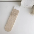 Calze a coste verticali color beige crema con etichetta del marchio su tavolo bianco - Taglia unica / Cachi