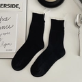 Women's black crew socks with white ruffled trim and vertical ribbed knit texture - One Size / Black