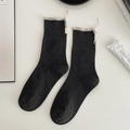 Chic black crew socks with vertical ribbing, cream rolled cuffs, and lace-up details - One Size / Dark Gray