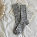 Chaussettes mi-mollet en tricot gris chiné à mouchetures colorées sur un livre blanc - Taille unique / Gris clair