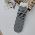 Calcetines gris oscuro con textura de canalé y empaquetado de cartón de la marca - Gris claro