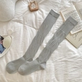 Chaussettes hautes grises en maille côtelée style ballet sur une literie blanche - Taille unique / Gris