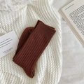 Thick dark brown ribbed knit socks for winter warmth shown on a soft white blanket - Reddish Brown