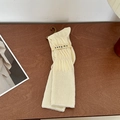 Creamy white knee-high socks with unique textured knit and stylish slouchy design - Creamy White