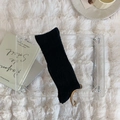Detailed close-up of black ribbed knit crew socks with elegant golden hook accessories - One Size / Black