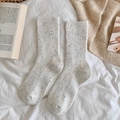 Cremefarbene Wollsocken mit bunten Sprenkeln und Rippstrickmuster in gemütlicher Szene - Einheitsgröße / Cremeweiß