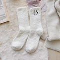 Soft white coral fleece socks featuring a cute black smiley face embroidery - One Size / Cream