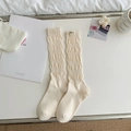 Beige slouch socks with wave texture and woven label in a cozy minimalist setting - One Size / Creamy White