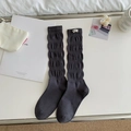 Dark grey slouch socks with ribbed texture and white woven label in a minimal setting - One Size / Gray