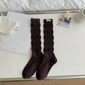 Dark brown slouch socks with wavy texture and white woven label in minimalist style - One Size / Coffee