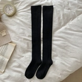 Thick black over-the-knee socks for women with warm ribbed cuffs in a cozy winter setting - Black