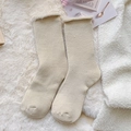 Thick light beige knit winter socks featuring white fuzzy fleece cuffs on soft background - One Size / Beige
