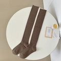Thick dark brown over-knee socks in vertical ribbed knit on a minimalist white table - Dark Coffee