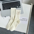 Cream white ribbed mid-calf socks with vintage C letter patch in a minimalist setting - One Size / Creamy White