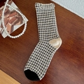 Vintage-Socken mit schwarz-weißem Karomuster und Waffelstruktur auf einem Holztisch - Einheitsgröße / Kariert