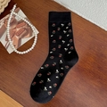 Vintage schwarze Socken mit Blumenmuster auf einem rustikalen Holzhintergrund - Einheitsgröße / Blumen