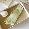 Light green vertical striped ribbed mid-calf socks neatly folded on a white wooden tray - One Size / Green
