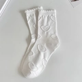 Sweet white crew socks with heart patterns and ruffle edges in a flat lay view - One Size / White Heart Mid-Tube Socks