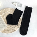 Elegante schwarze Spitzensocken mit Blumenmuster auf einer rustikalen Strohmatte - Einheitsgröße / Schwarz