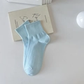 Light blue cotton knit socks with ribbed cuffs shown on a clean white desk background - One Size / Blue