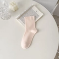 Minimalist light pink cotton knit mid-calf crew sock on an aesthetic book background - Light Orange
