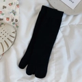 Classic black two-toe split socks in cotton knit styled on a white textured background - One Size / Black