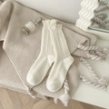 Gemütliche weiße Wollsocken mit Rüschenrand und Rippenmuster auf weichem Strickhintergrund - Einheitsgröße / Weiß
