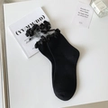 Süße schwarze Socken mit Spitzenbesatz und Schleife auf weißem Hintergrund - Einheitsgröße / Schwarz