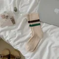 Beige ribbed crew socks with green and brown stripes in a cozy minimalist home aesthetic - Double Stripe