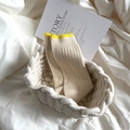 Chunky knit cream mid-calf socks with yellow trim folded in a woven basket - One Size / Yellow Trim