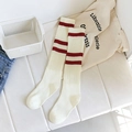 Creamy white knee-high socks featuring red double stripes and vertical ribbed texture - One Size / White with Red Stripes