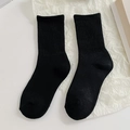 Pair of black ribbed mid-calf crew socks with solid color and fine knit texture - Solid Black