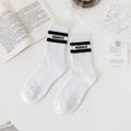 Chaussettes blanches en coton avec rayures noires et lettres dans un cadre chaleureux - Blanc avec lettre noire