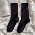 Klassische schwarze Socken aus weichem Strickgewebe auf stylischem Hintergrund - Einheitsgröße / Schwarz