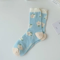 Light blue crew socks with white floral patterns and ruffled edges on white background - One Size / Blue