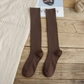 Vertical rib knit long socks in dark brown finish placed on a vintage wooden background - One Size / Coffee